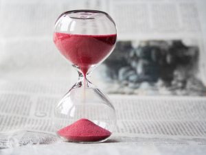 clear hourglass with pink sand running through it.