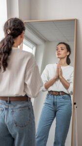 Woman of God standing in front of a mirror with her hands together for prayer